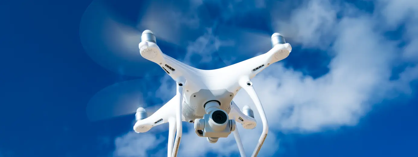 Drone biano in volo cielo con nuvole come sfondo